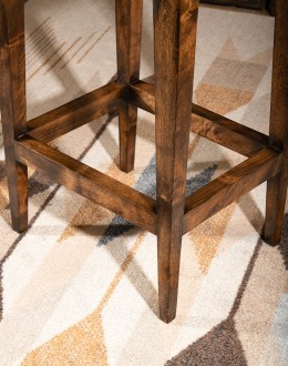 Cheyenne Saddle Stool in top-grain tufted leather with a two-toned color and brass nail heads, on a Knotty Alder hardwood frame with a footrest for added comfort and support. Available in bar and counter height. Backless design saves space