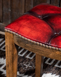 saddle stool with tufted red leather seat cushion