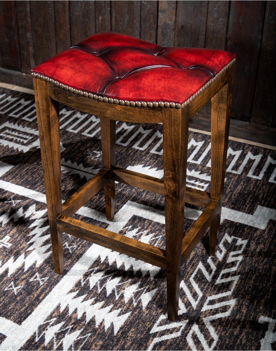 saddle stool with tufted red leather seat cushion