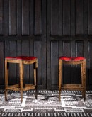 saddle stool with tufted red leather seat cushion