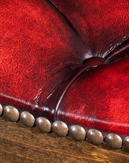 saddle stool with tufted red leather seat cushion