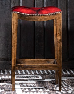 saddle stool with tufted red leather seat cushion