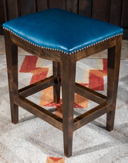 An image showcasing the Levi Saddle Stool, a masterpiece of American craftsmanship. The stool features a denim blue aniline dyed full grain leather seat, lightly sanded for a distressed look. Its clean-lined design boasts solid Alder Wood straight legs, r