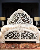 spanish style bed with a white washed wood finish and carvings