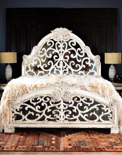 spanish style bed with a white washed wood finish and carvings