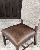 Dining Chair with a solid hardwood frame, top grain leather seat cushion, tweed textured fabric on the inside back, and floral-patterned stamped cowhide on the outer back, adorned with brass nail tacks.