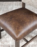 Dining Chair with a solid hardwood frame, top grain leather seat cushion, tweed textured fabric on the inside back, and floral-patterned stamped cowhide on the outer back, adorned with brass nail tacks.