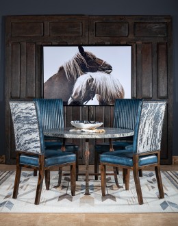 American-made Huckleberry Leather Dining Chair in blue top grain leather with hand-antiqued details, modern rustic frame, and unique hair-on-hide floral pattern on the back.