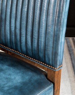 American-made Huckleberry Leather Dining Chair in blue top grain leather with hand-antiqued details, modern rustic frame, and unique hair-on-hide floral pattern on the back.