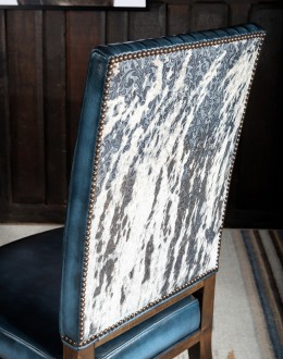 American-made Huckleberry Leather Dining Chair in blue top grain leather with hand-antiqued details, modern rustic frame, and unique hair-on-hide floral pattern on the back.