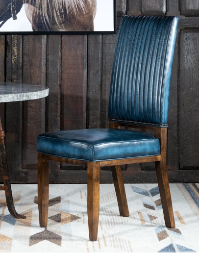 American-made Huckleberry Leather Dining Chair in blue top grain leather with hand-antiqued details, modern rustic frame, and unique hair-on-hide floral pattern on the back.