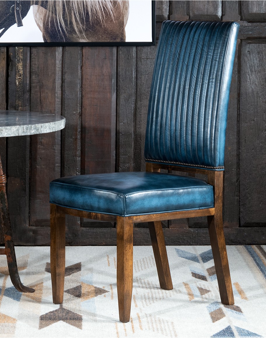 American-made Huckleberry Leather Dining Chair in blue top grain leather with hand-antiqued details, modern rustic frame, and unique hair-on-hide floral pattern on the back.