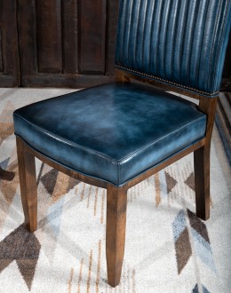 American-made Huckleberry Leather Dining Chair in blue top grain leather with hand-antiqued details, modern rustic frame, and unique hair-on-hide floral pattern on the back.