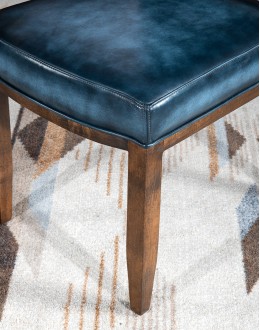 American-made Huckleberry Leather Dining Chair in blue top grain leather with hand-antiqued details, modern rustic frame, and unique hair-on-hide floral pattern on the back.