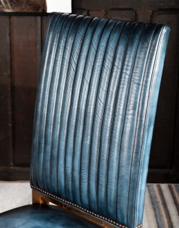 American-made Huckleberry Leather Dining Chair in blue top grain leather with hand-antiqued details, modern rustic frame, and unique hair-on-hide floral pattern on the back.