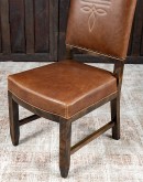 Sundance Saddle Leather Dining Chair featuring solid American Alder Wood frame with black walnut finish, saddle tan leather upholstery, brass nail tacks, and boot stitch emblem.