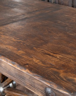 Western-style Pioneer Wagon Wheel Pub Table featuring a solid hand-forged iron base with a detailed wagon wheel design, finished in natural rust and sealed for durability. The top is crafted from distressed Chilean Pine, adding rustic elegance to the piec