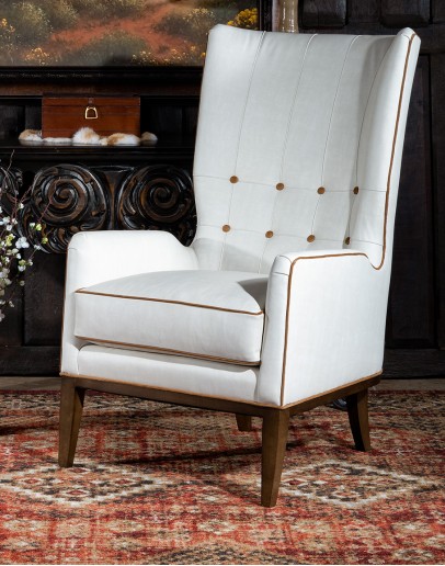 cream leather accent chair with exposed wood frame and contrasting welts