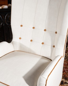 cream leather accent chair with exposed wood frame and contrasting welts