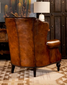 oversized leather wingback chair with a shearling hide seat cushion,saddle leather chair