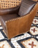 distressed brown leather chair with boot stitch emblem on seat back