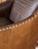 distressed brown leather chair with boot stitch emblem on seat back