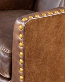 distressed brown leather chair with boot stitch emblem on seat back