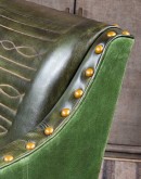 distressed olive color leather chair with boot stitch emblem on seat back