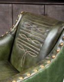 distressed olive color leather chair with boot stitch emblem on seat back