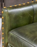 distressed olive color leather chair with boot stitch emblem on seat back