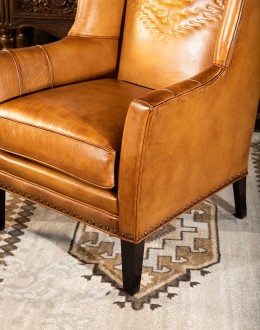 distressed brown leather chair with native American inspired stitch emblem on seat back