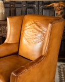 distressed brown leather chair with native American inspired stitch emblem on seat back