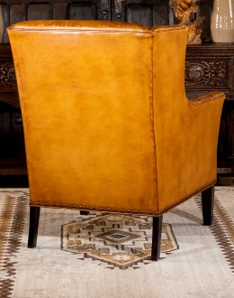 distressed brown leather chair with native American inspired stitch emblem on seat back