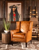 distressed brown leather chair with native American inspired stitch emblem on seat back