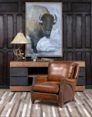 The Cowboy AF Leather Chair is a western-style armchair with a luxurious full-grain leather finish, hand-burnished leather details, and brushed sueded leather accents on the out arms. The chair features plush seat and back cushions, nickel nail trim, and