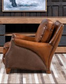 The Cowboy AF Leather Chair is a western-style armchair with a luxurious full-grain leather finish, hand-burnished leather details, and brushed sueded leather accents on the out arms. The chair features plush seat and back cushions, nickel nail trim, and