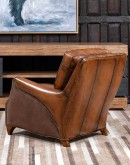 The Cowboy AF Leather Chair is a western-style armchair with a luxurious full-grain leather finish, hand-burnished leather details, and brushed sueded leather accents on the out arms. The chair features plush seat and back cushions, nickel nail trim, and