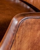 Downtown Cowboy Chair - a small scaled leather accent chair with warm brown, hand burnished leather, cowboy boot stitch emblem on the inside seat back, and a retro-style frame. Expertly crafted in the USA with 8-way hand tied construction, this high-quali
