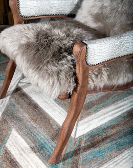 Kodiak Arm Chair American-made Kodiak Arm Chair with solid black walnut frame, crocodile-pattern stamped leather arms, and luxurious Angora hair cushions, accented by nickel nail heads.