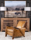 A luxurious Lucky Leather Chair featuring a rich tan full-grain leather upholstery, contrasting leather accents on the arms, brass nail tacks, and a unique leather horseshoe detail.