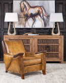 A luxurious Lucky Leather Chair featuring a rich tan full-grain leather upholstery, contrasting leather accents on the arms, brass nail tacks, and a unique leather horseshoe detail.