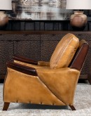 A luxurious Lucky Leather Chair featuring a rich tan full-grain leather upholstery, contrasting leather accents on the arms, brass nail tacks, and a unique leather horseshoe detail.