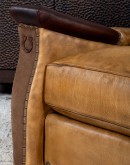 A luxurious Lucky Leather Chair featuring a rich tan full-grain leather upholstery, contrasting leather accents on the arms, brass nail tacks, and a unique leather horseshoe detail.