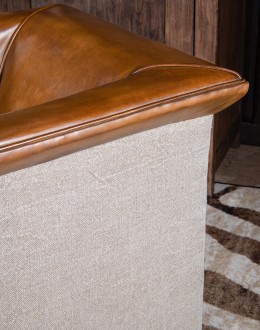 Image of the American-made Polo Club Chair showcasing its full grain leather upholstery with hand burnished details, and luxurious cream nylon tweed-textured fabric wrapping the outside arms and back, signifying modern rustic elegance