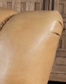 Introducing the Tulip Club Chair - a beautifully designed, American-made chair that's sure to elevate any living space! This image showcases the chair's stunning palomino-colored, full-grain leather and the cream shearling hide seat cushion, which provide