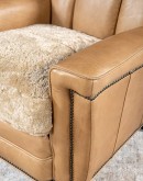 Introducing the Tulip Club Chair - a beautifully designed, American-made chair that's sure to elevate any living space! This image showcases the chair's stunning palomino-colored, full-grain leather and the cream shearling hide seat cushion, which provide