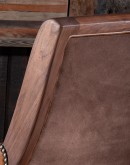 The Yachtsman's Leather Chair is a stunning piece of furniture designed with a modern rustic aesthetic. The chair features a solid black walnut frame and armrests wrapped in thick true saddle leather. The leather is a full grain hide with hand burnished d