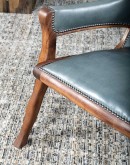 Yachtsman’s Sky Leather Chair with grey-blue leather, black walnut frame, and brindle cowhide back, accented with nickel nail heads.