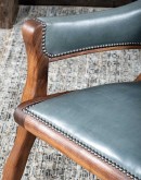 Yachtsman’s Sky Leather Chair with grey-blue leather, black walnut frame, and brindle cowhide back, accented with nickel nail heads.