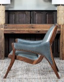 Yachtsman’s Sky Leather Chair with grey-blue leather, black walnut frame, and brindle cowhide back, accented with nickel nail heads.